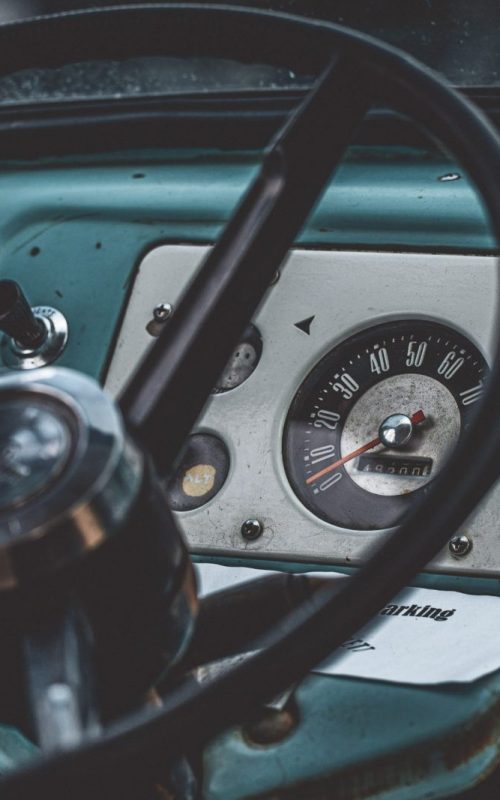 Closeup shot of a black steering wheel inside of a blue car A closeup shot of a black steering wheel inside of a blue car